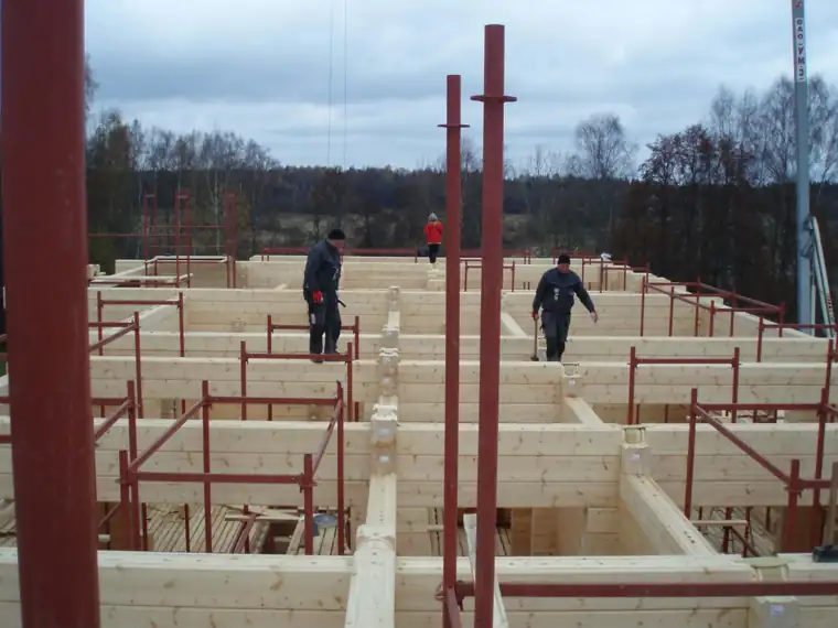 Ülaltvaade laotud palkseintele, mehed tööl